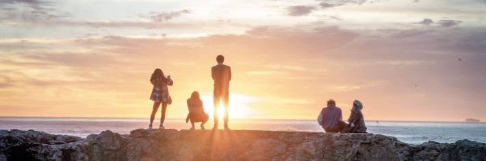 group of people overlooking a sunset